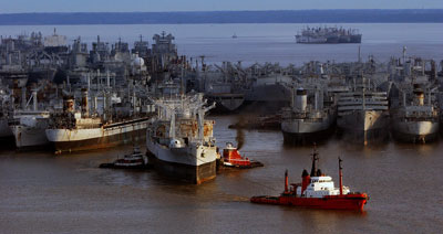 Tugs ease a World War II oiler from its anchorage in the James River 