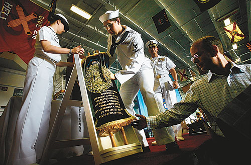 Lt. Julia Weber and Petty Officer 3rd Class Jesse Kopelman set the Torah on the hangar deck of the carrier Harry S. Truman. The Torah is expected to remain on the ship for 41 years. 
 
 
 
 
 
 
